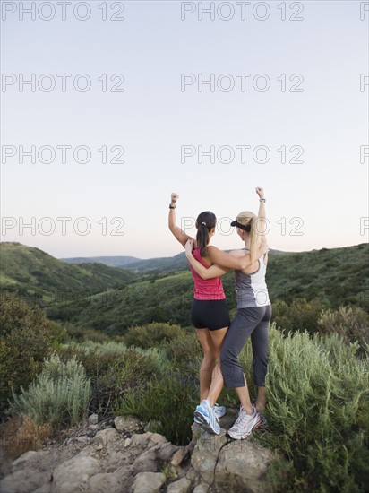 Two women raising their arms in victory.