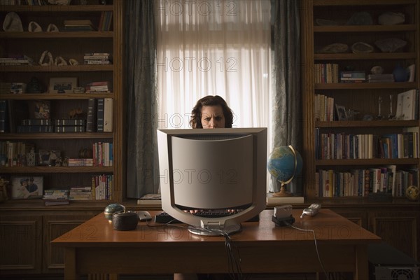Woman sitting at desk in home office. Photo : Stewart Cohen