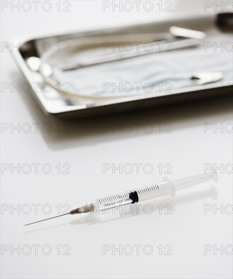 Syringe beside tray of medical supplies. Photo : Jamie Grill