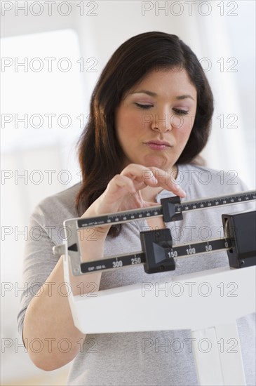 Disappointed woman standing on scale.