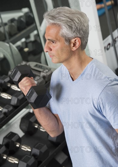 Man lifting free weights at the gym.