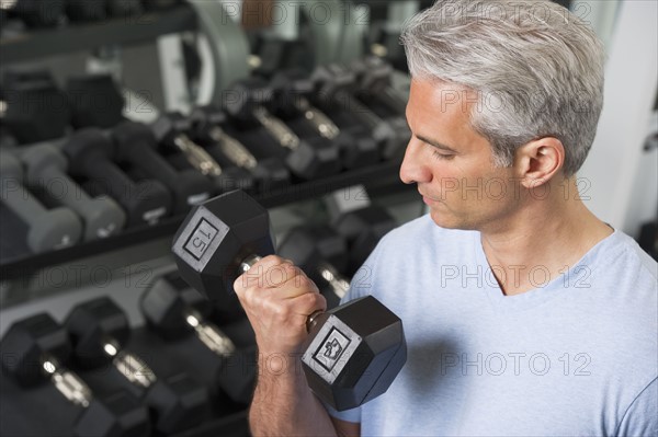 Man lifting free weights at the gym.