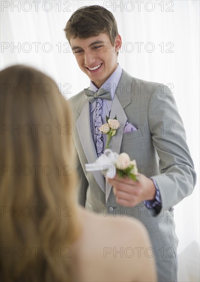 Man giving corsage to woman.