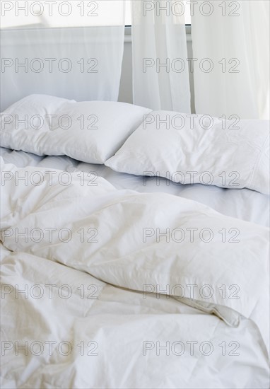 Bed with white linens.
