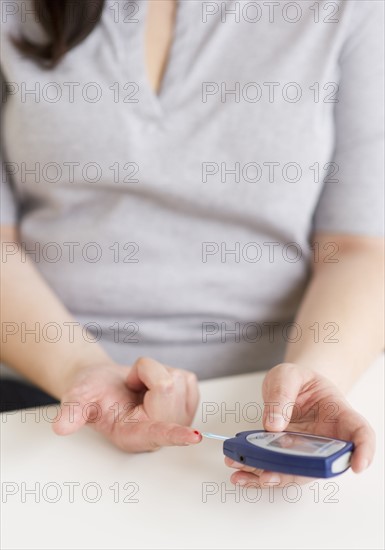 Woman using a blood sugar monitor.
