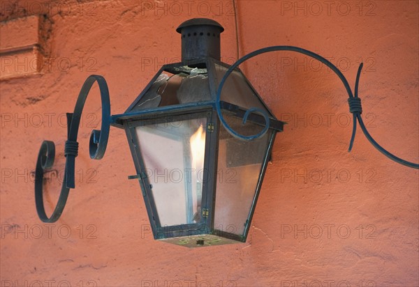 Lantern on an orange stucco wall.