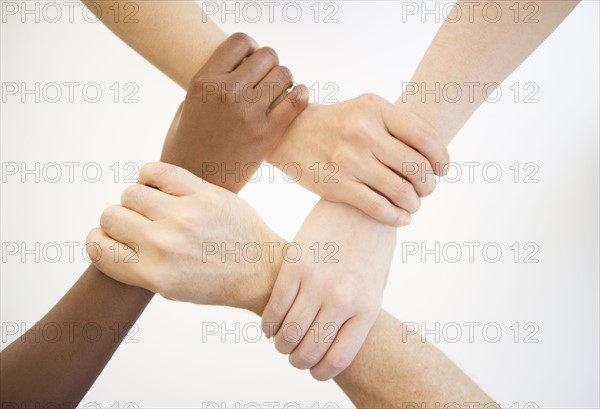 Four hands holding wrists of other people.