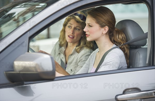 Mother teaching her daughter how to drive.