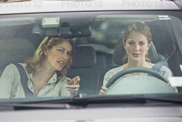 Mother teaching her daughter how to drive.