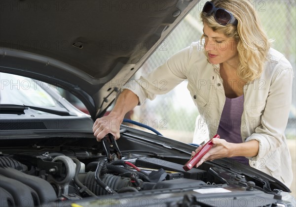 Woman fixing car.