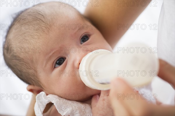 Mother feeding her baby a bottle.