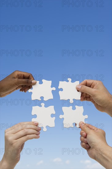 Hands holding puzzle pieces.