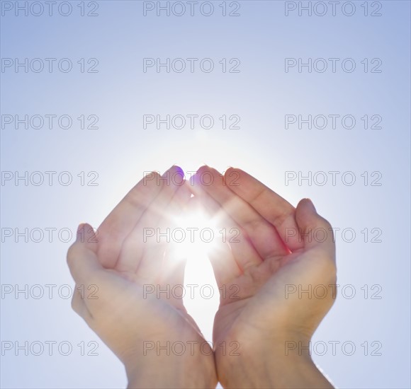 Hands framing sunshine.