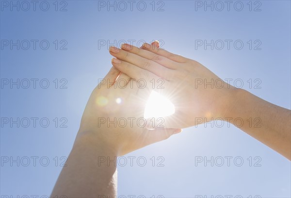 Hands framing sunshine.