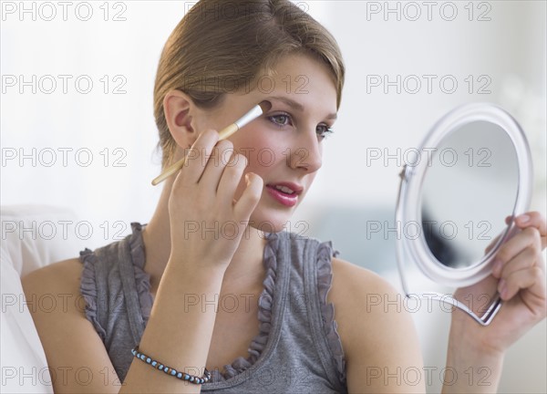 Woman putting on makeup.