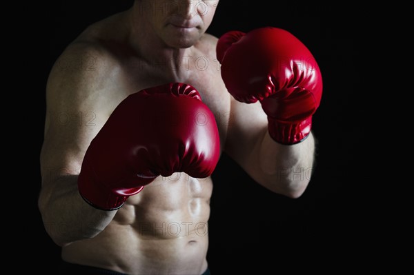 Boxer wearing red boxing gloves. Photo : Daniel Grill