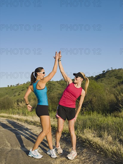 Two trail runners giving each other a high five.