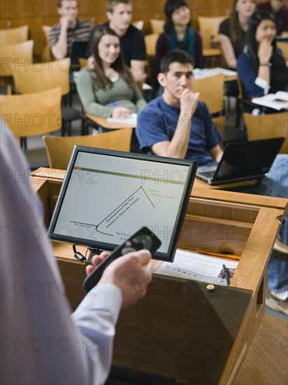 College professor giving lecture in lecture hall.