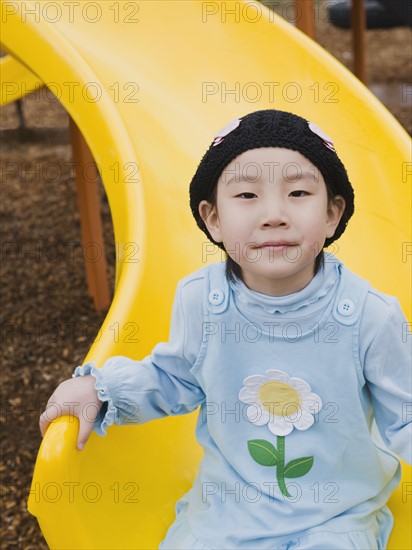 Elementary school student playing on slide at recess.