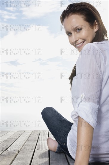 Pretty woman sitting on porch. Photo : momentimages