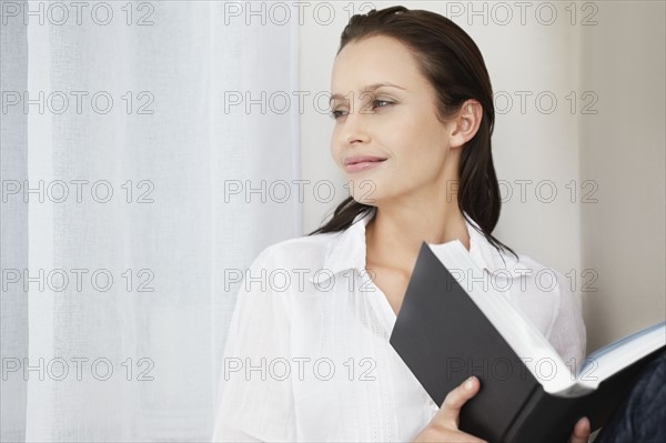 Pretty woman holding a book. Photo : momentimages