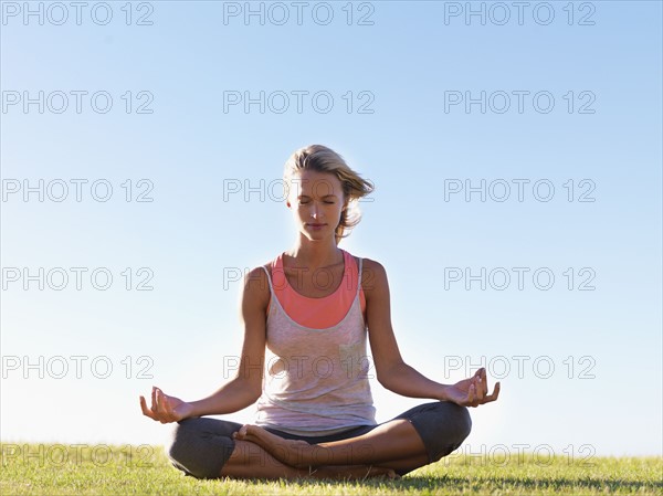 Woman meditating outside. Photo : momentimages