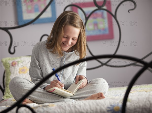 Young girl writing in her diary. Photo : Mike Kemp