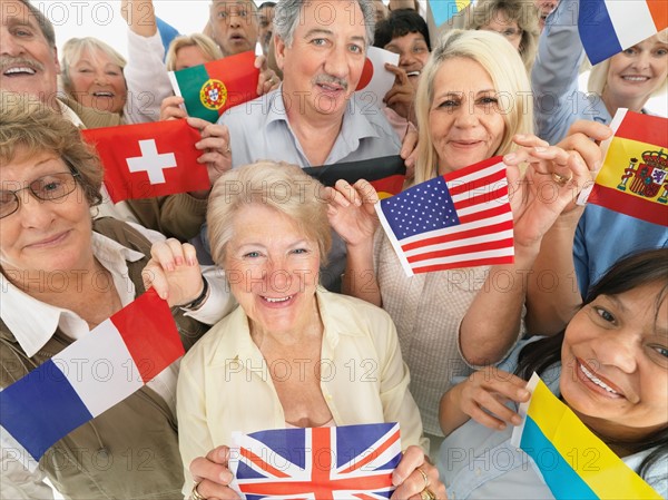 A group of people holding small flags. Photo : momentimages