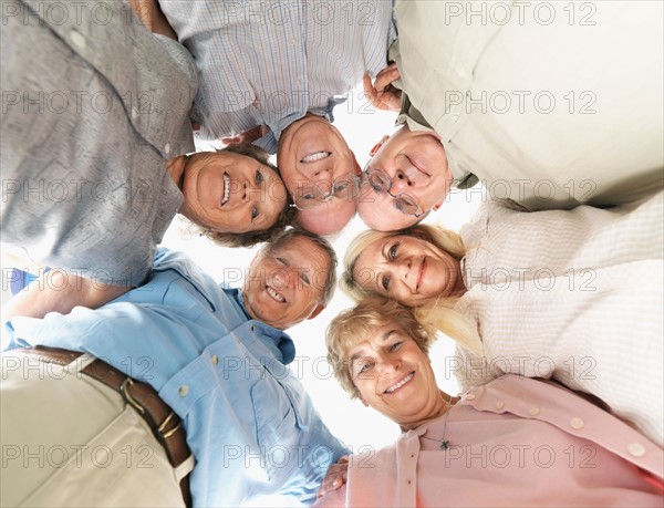 A group of people huddled together. Photo : momentimages