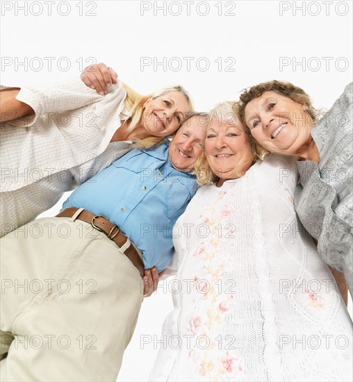 Four friends standing with their arms around each other. Photo : momentimages