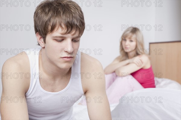 Couple sitting on bed after arguing. Photo : Take A Pix Media