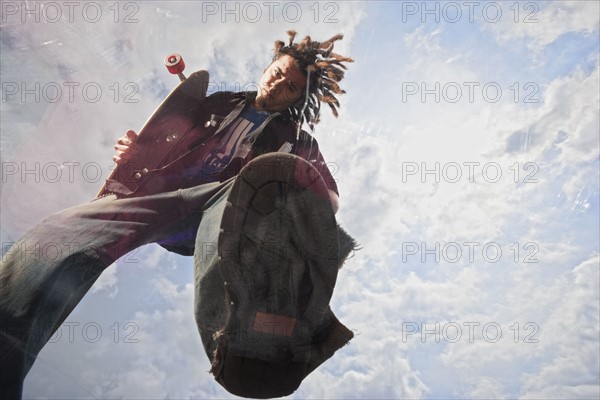 Teenage boy doing skateboard jump. Photo : Stewart Cohen