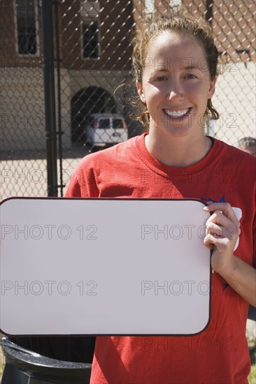 Teenage girl holding blank whiteboard. Photo : Stewart Cohen