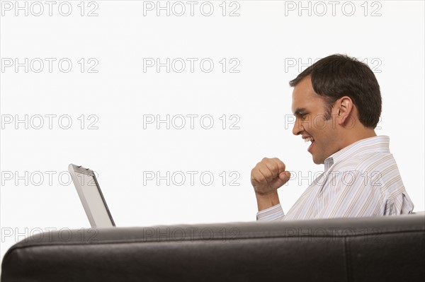 Excited man looking at laptop. Photo : K.Hatt