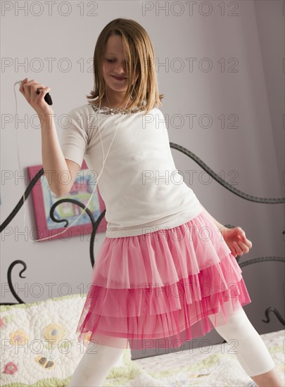 Young girl dancing on her bed. Photo : Mike Kemp