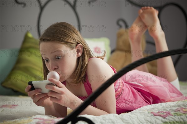 Surprised young girl reading text. Photo : Mike Kemp