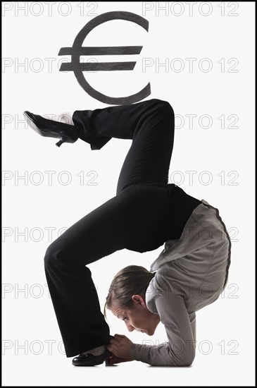 Euro symbol on top of contorted businesswoman. Photo : Mike Kemp