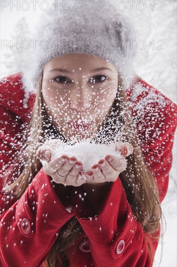 Woman blowing snow off her hands. Photo : Mike Kemp