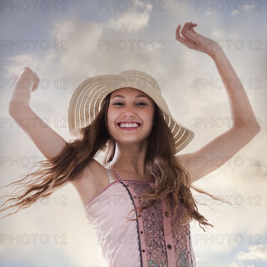 Happy woman holding her arms in the air. Photo : Mike Kemp