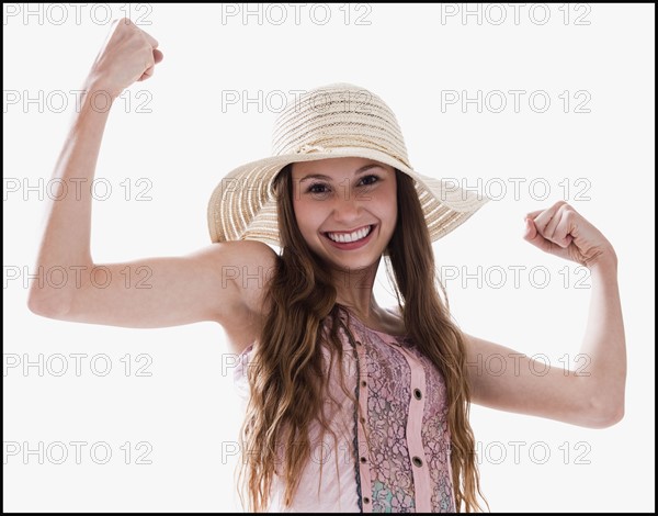 Smiling woman flexing her muscles. Photo : Mike Kemp