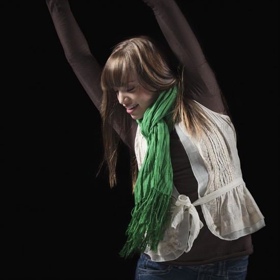 Female dancer with her arms raised above her head. Photo : Mike Kemp