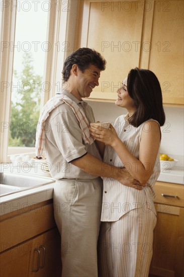 Couple embracing in the kitchen. Photo : Rob Lewine