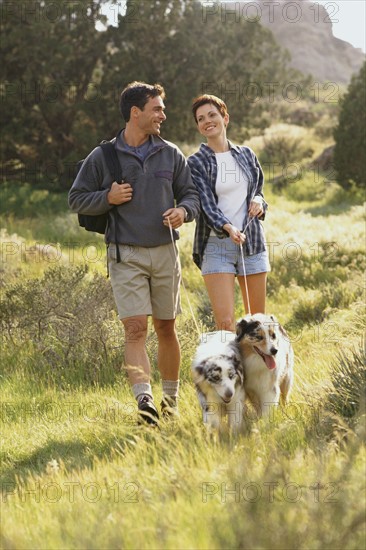 Couple walking their dogs in the countryside. Photo : Rob Lewine