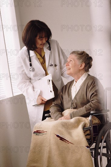 Doctor talking to senior woman in wheelchair. Photo : Rob Lewine