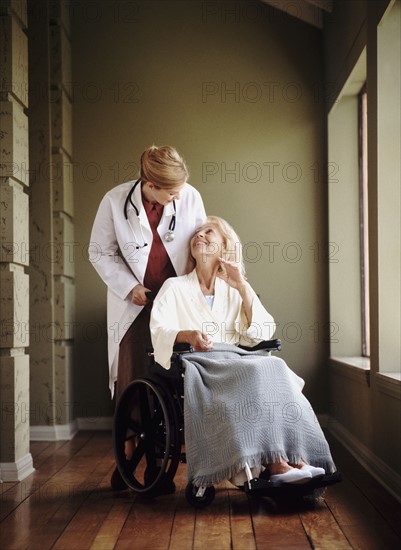 Doctor talking to woman in wheelchair. Photo : Rob Lewine