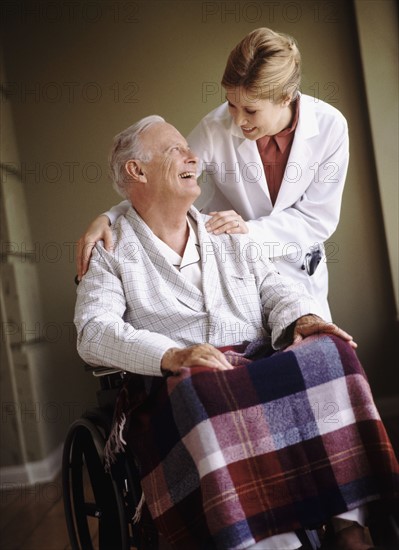 Doctor talking to senior man in wheelchair. Photo : Rob Lewine