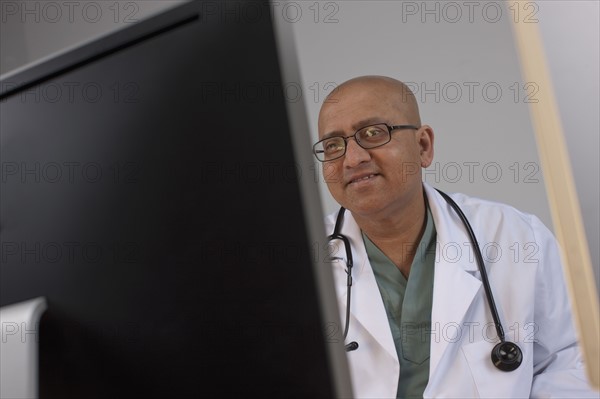 Doctor looking at computer monitor. Photo : Dan Bannister