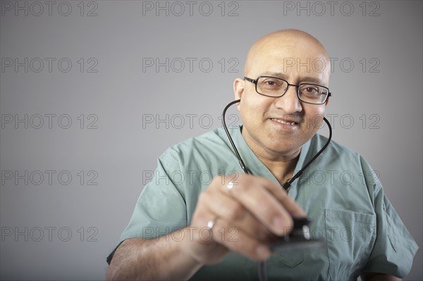 Doctor holding his stethoscope. Photo : Dan Bannister