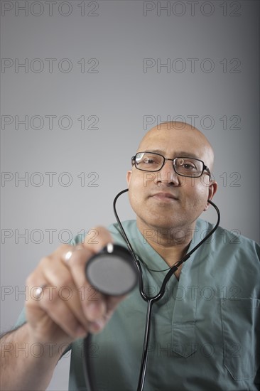 Doctor holding his stethoscope. Photo : Dan Bannister