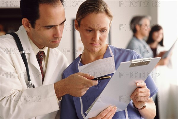 Doctor and nurse looking at chart. Photo : Rob Lewine